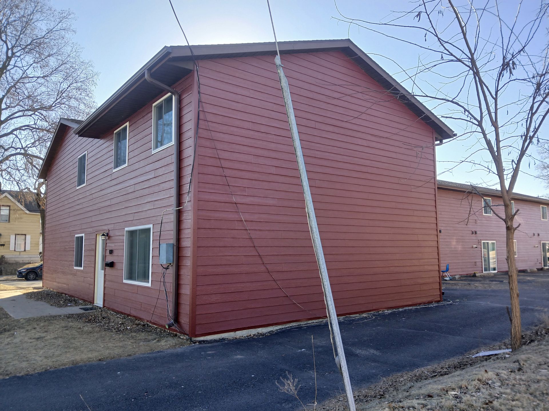 A red house with a lot of windows and a tree in front of it