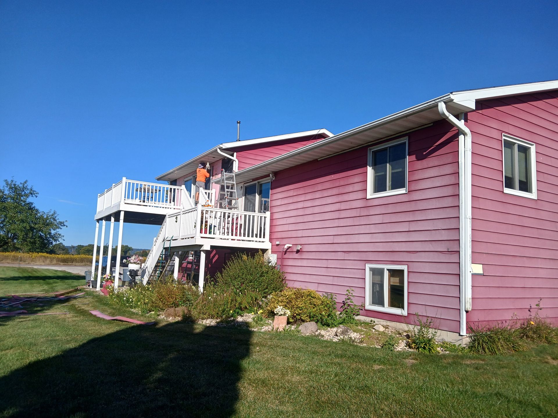 A pink house with a white deck and stairs