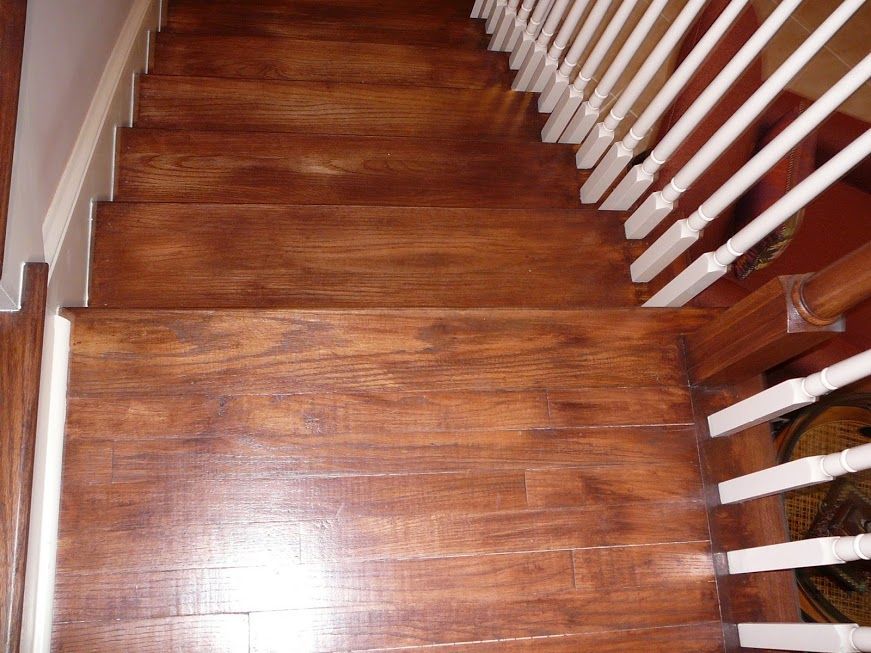 Wooden staircase with dark brown treads and white railing.