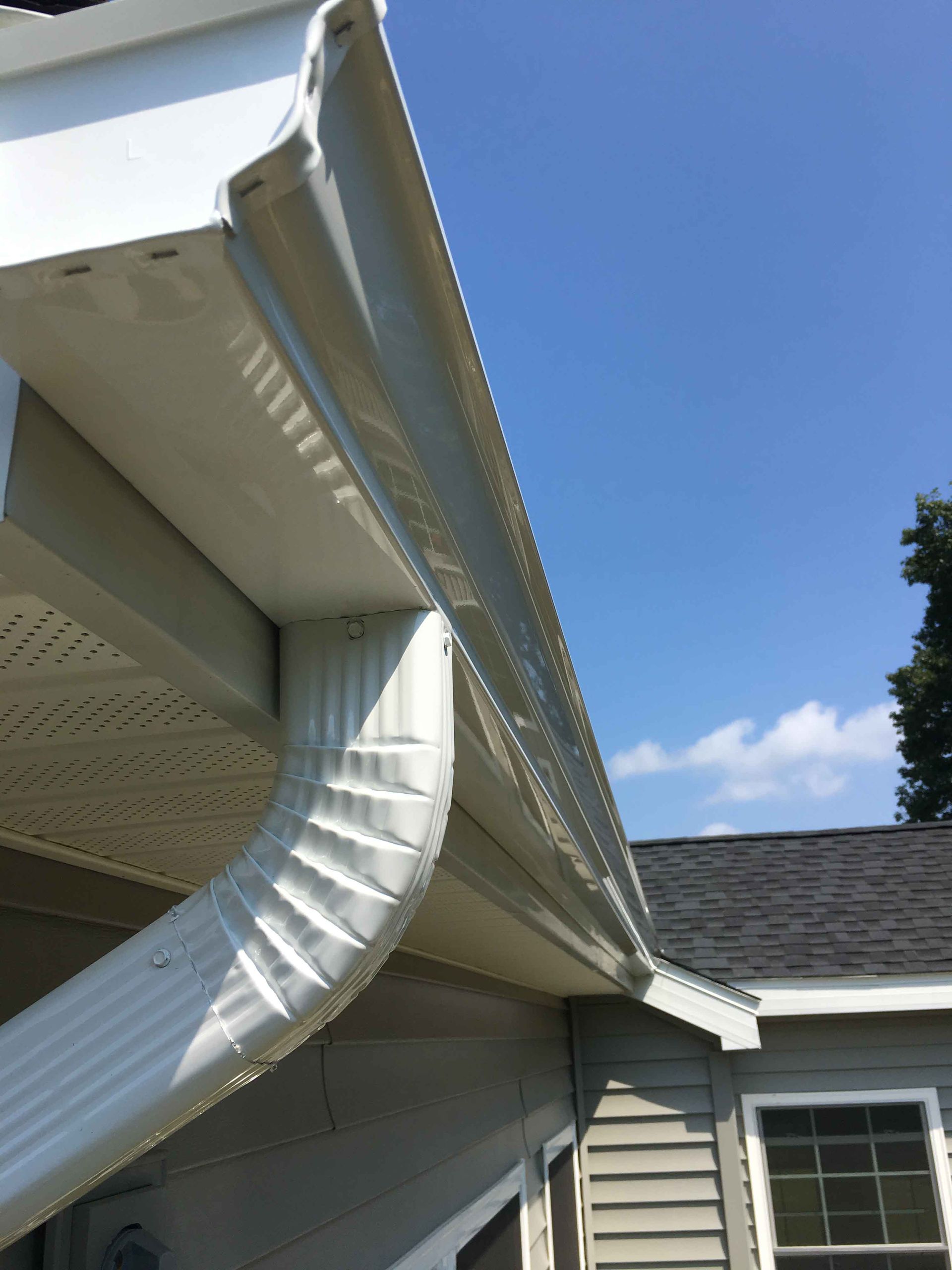 A white gutter on the side of a house