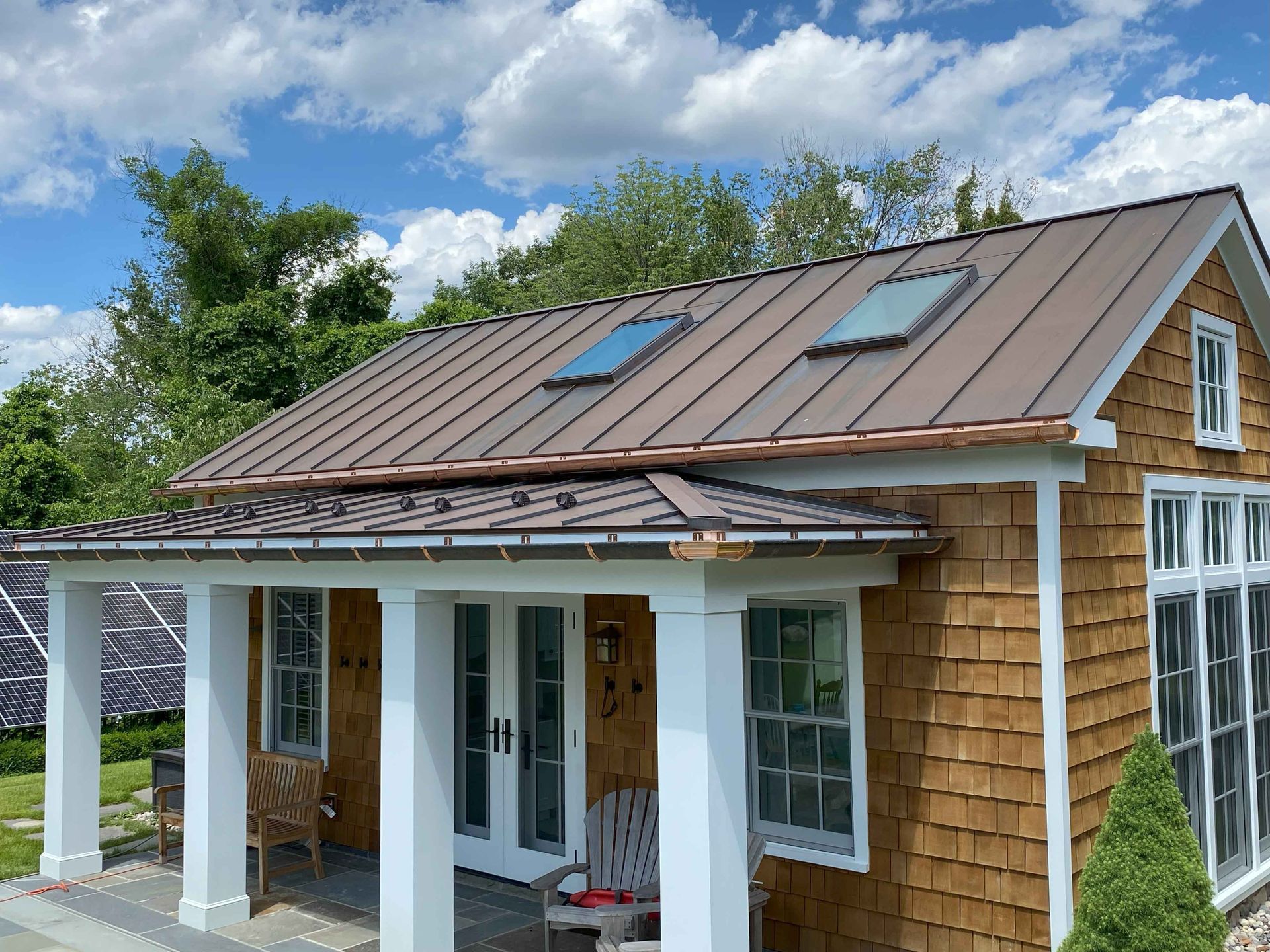 A small house with a brown roof and a porch