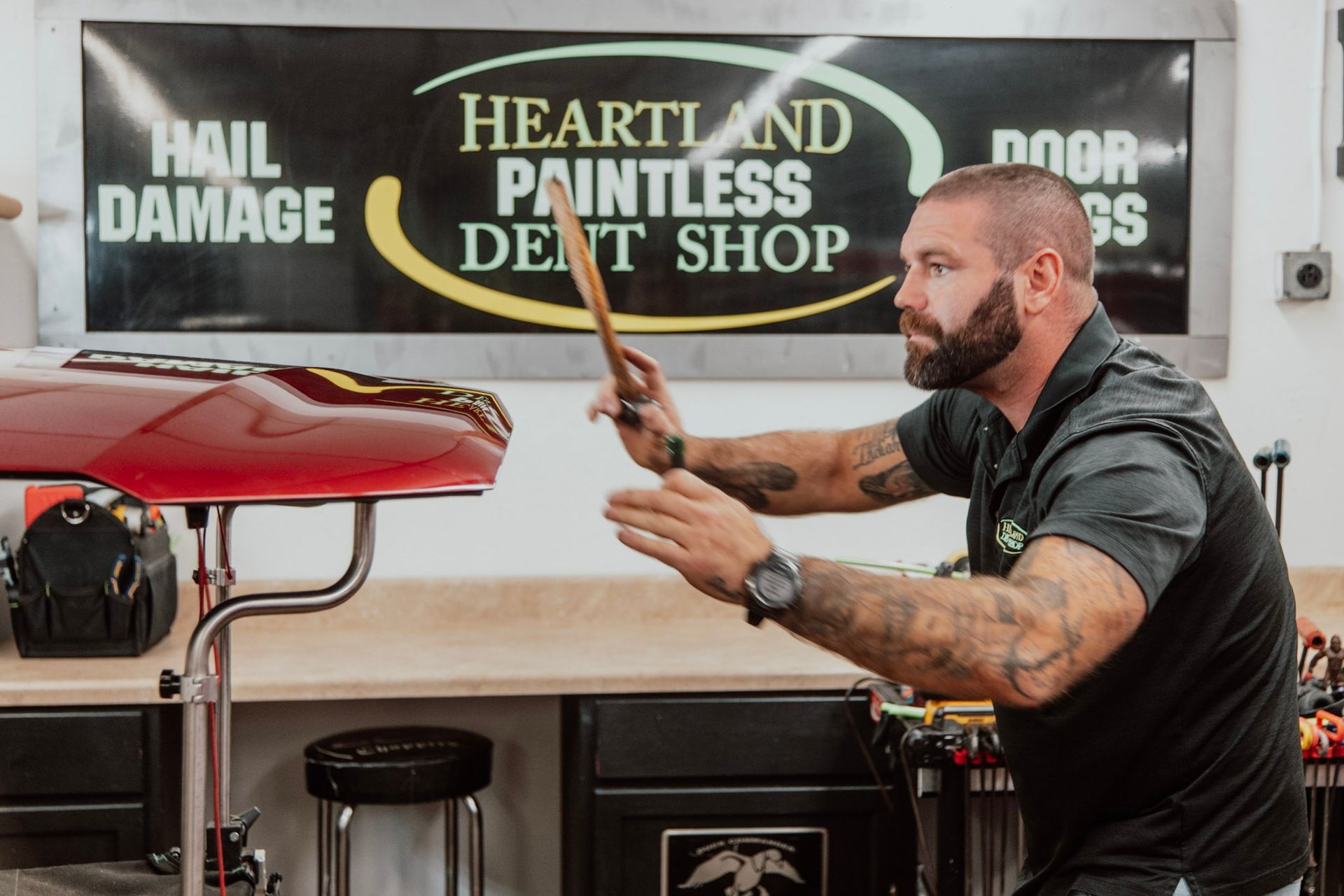 Man using tool on car at 