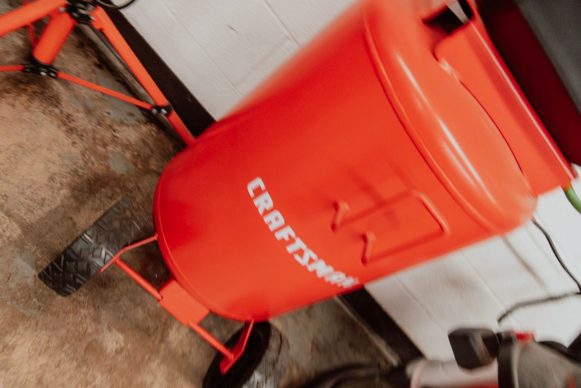 Orange Craftsman cement mixer in a garage setting.