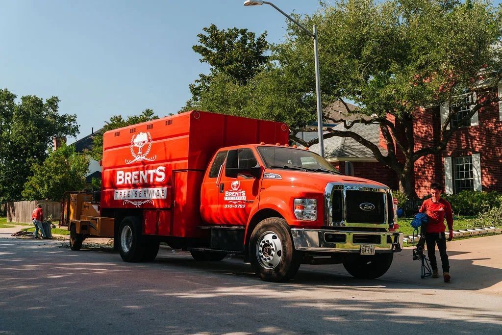 Red Bront's Land Clearing truck parked on a street with a worker nearby.
