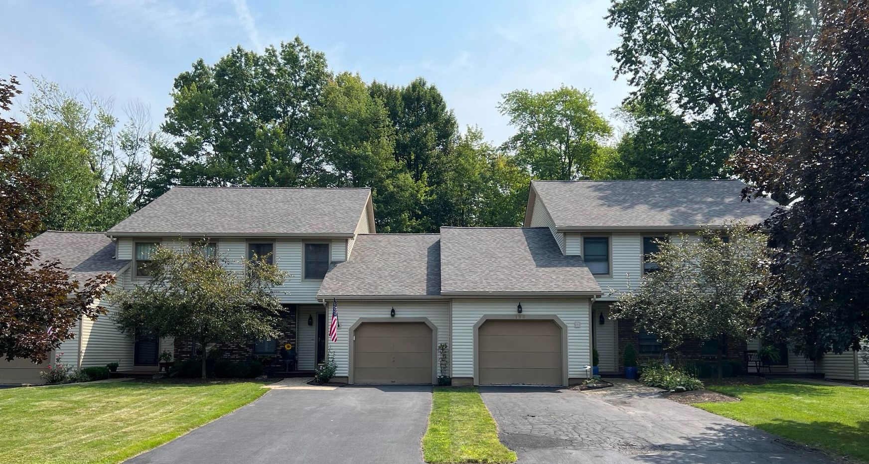 A couple of houses with two garages in front of them