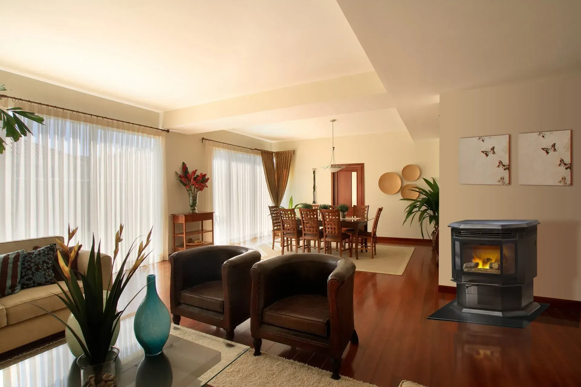 Living room with a fireplace, two brown armchairs, dining area visible in background.