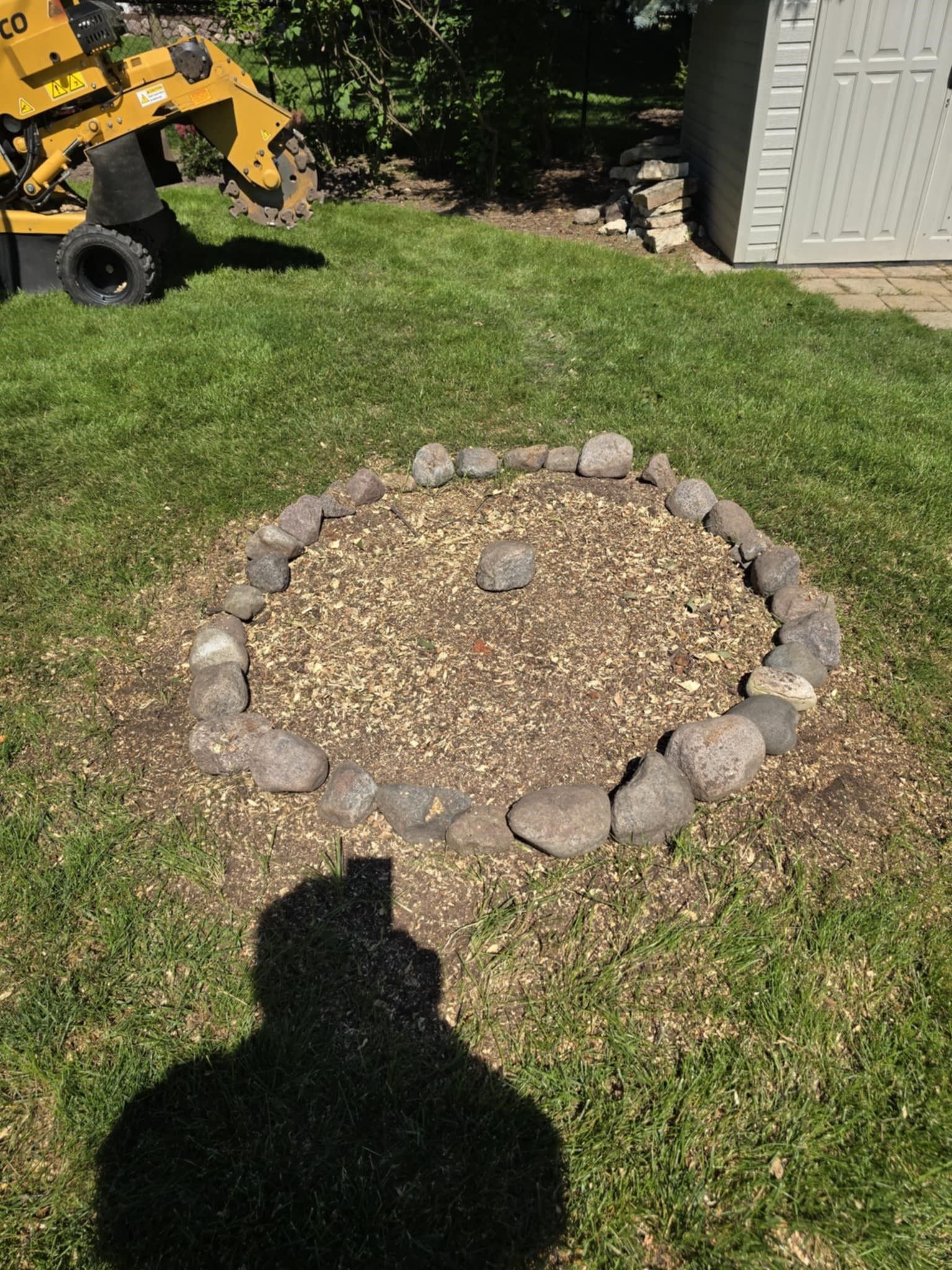 A circle of rocks is sitting in the middle of a lush green field.