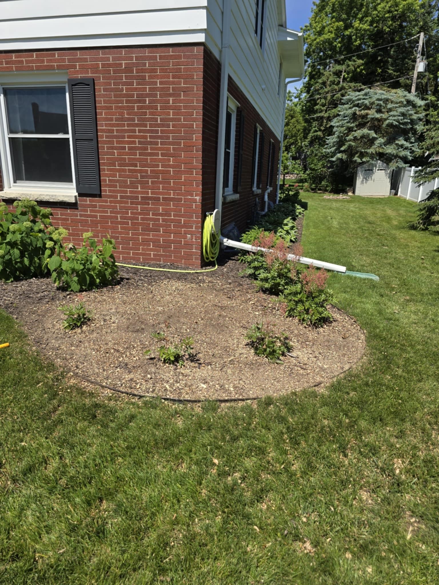 A brick house with a large lawn in front of it.