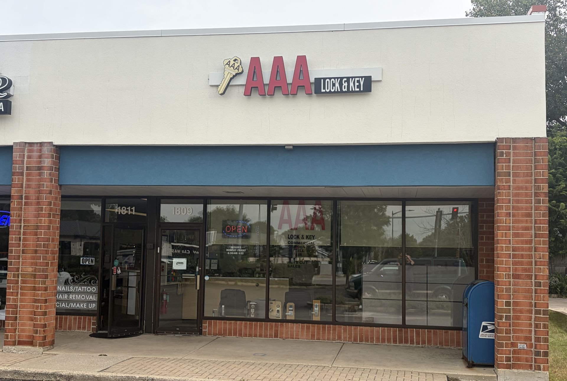 AAA office storefront with glass windows, red brick columns, and blue awning