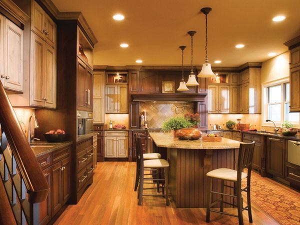 Warm wood kitchen with island, pendant lights, and large windows in a cozy, well-lit interior.