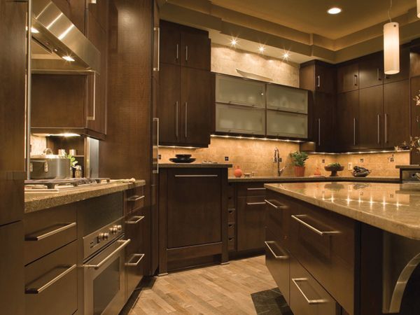 Modern kitchen with dark wood cabinets, stainless appliances, and a granite island countertop