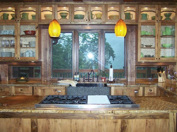 Warm rustic kitchen with granite island, pendant lights, and large window over the sink