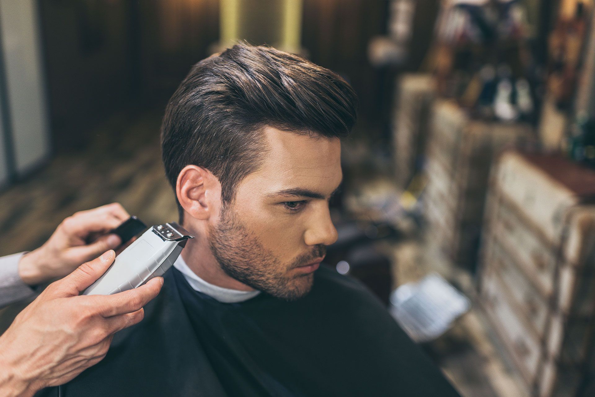 Man getting haircut with clippers at a barbershop.