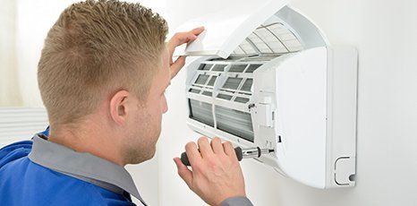 Technician repairing an Air Conditioning Unit