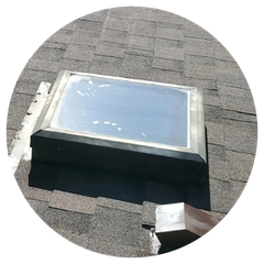 A skylight is sitting on top of a roof.