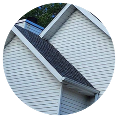 A house with a black roof and white siding is in a circle.