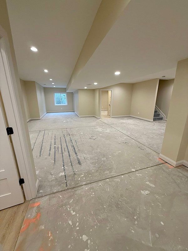 Empty beige unfinished basement room with recessed lights and bare concrete floor