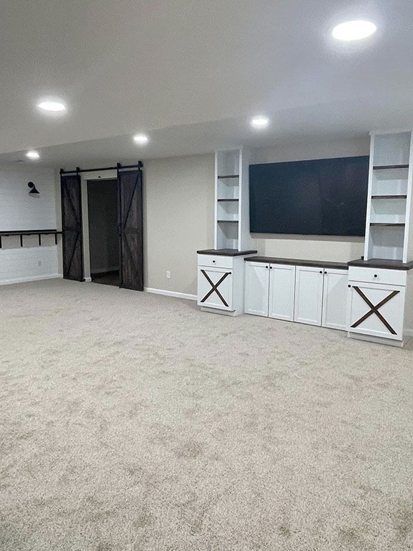 Spacious carpeted room with white built-in cabinets, and recessed ceiling lights