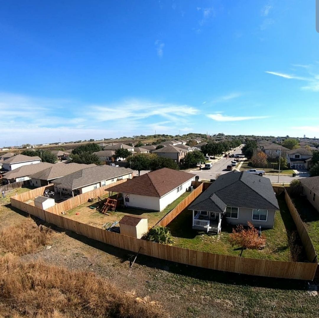 An aerial view of a residential area with houses and a wooden fence