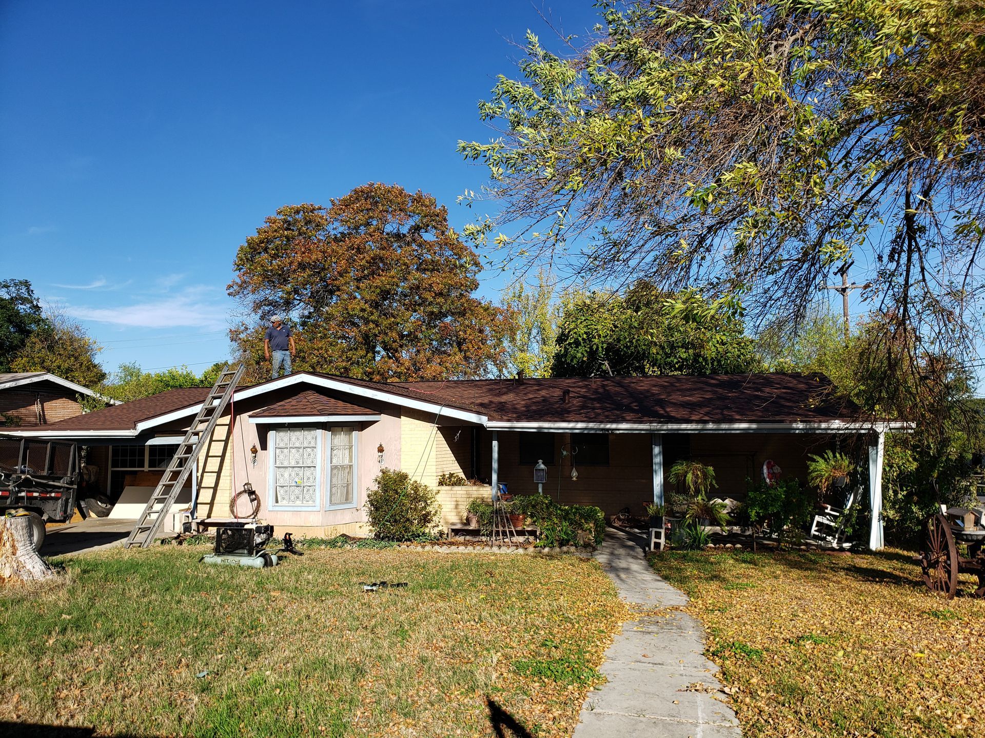 A house with a brown roof and a ladder in front of it