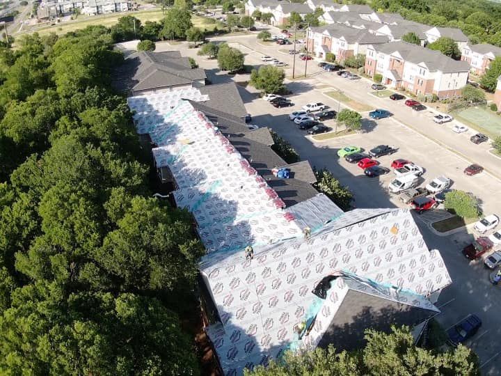 An aerial view of a building with a lot of cars parked in front of it