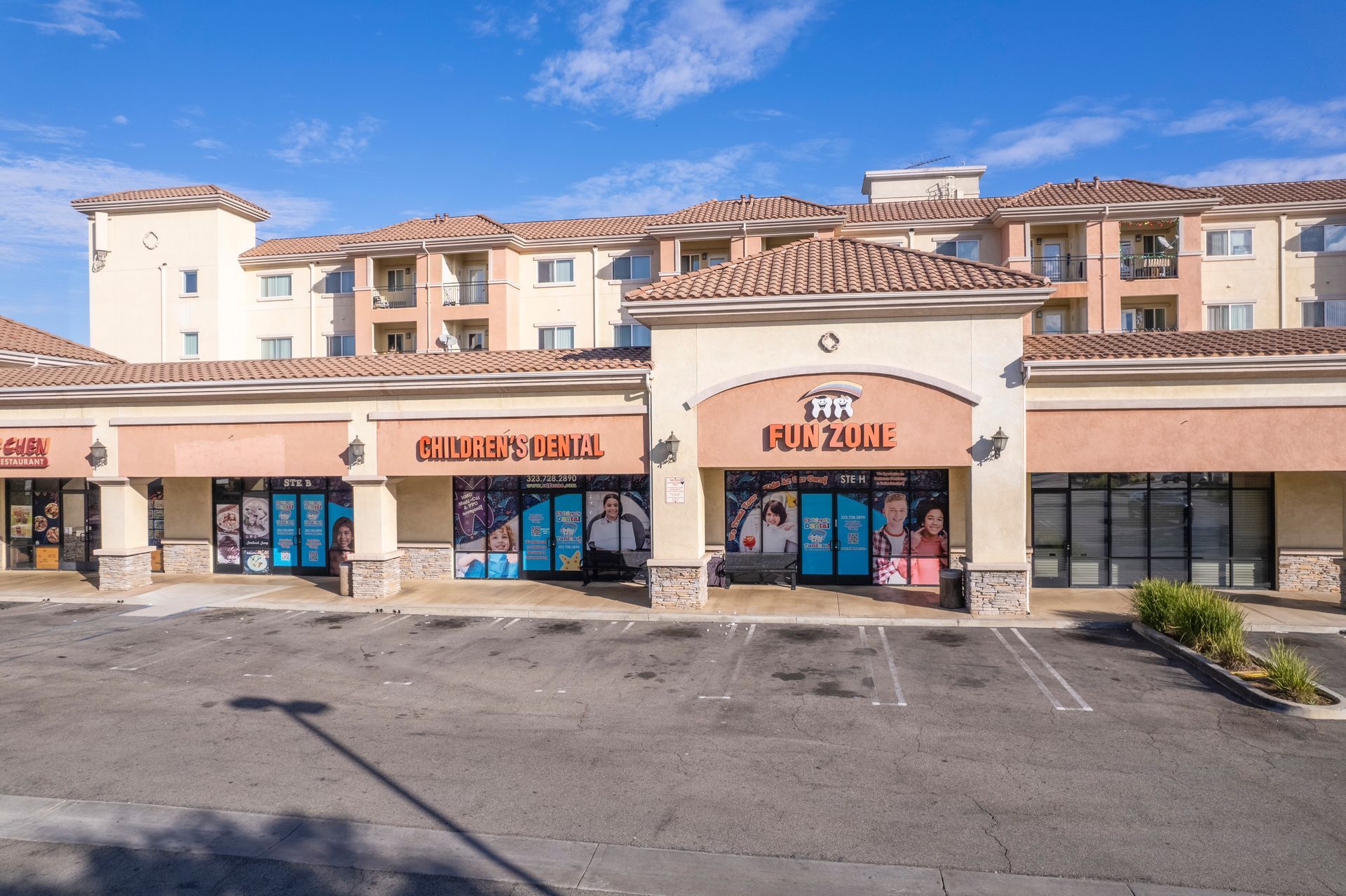 A large building with a lot of windows and a parking lot in front of it.