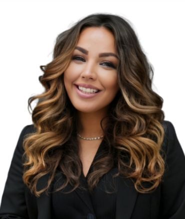 A woman with long curly hair is smiling and wearing a black jacket