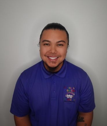 A man wearing a purple polo shirt with a tattoo on his arm