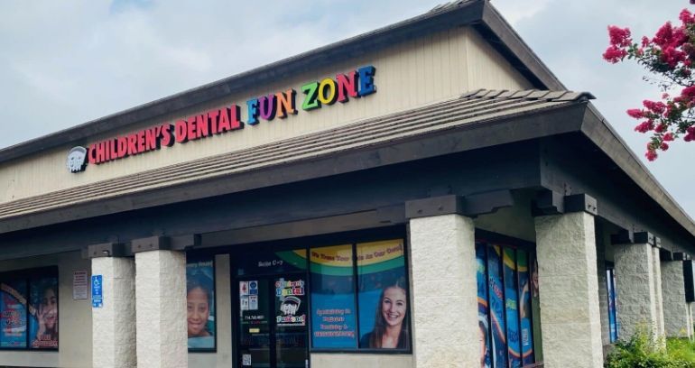 The front of a children 's dental office with a sign that says children 's dental fun zone.