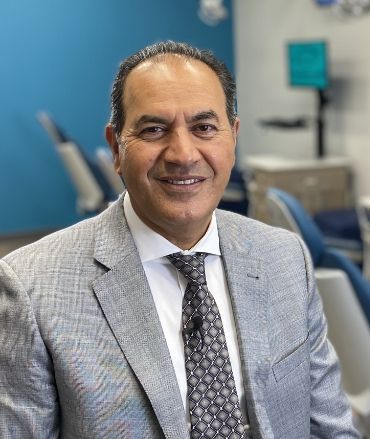 A man in a suit and tie is smiling for the camera.