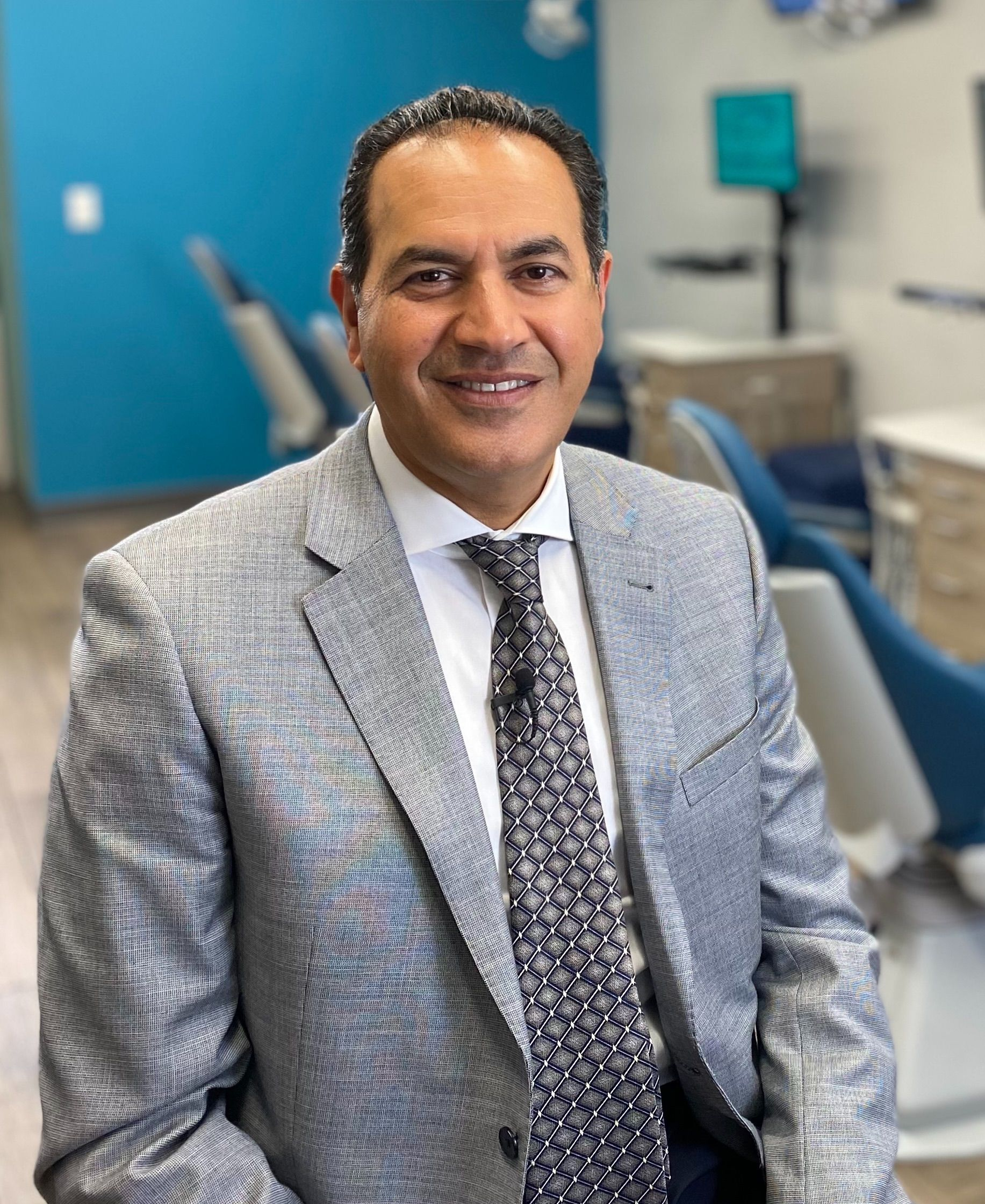 A man in a suit and tie is smiling for the camera.