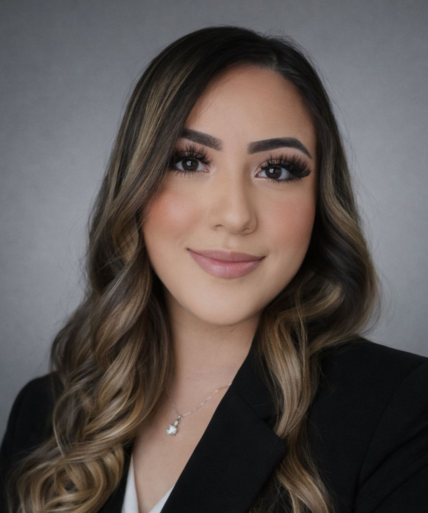 A woman with long hair is wearing a black shirt and smiling for the camera.