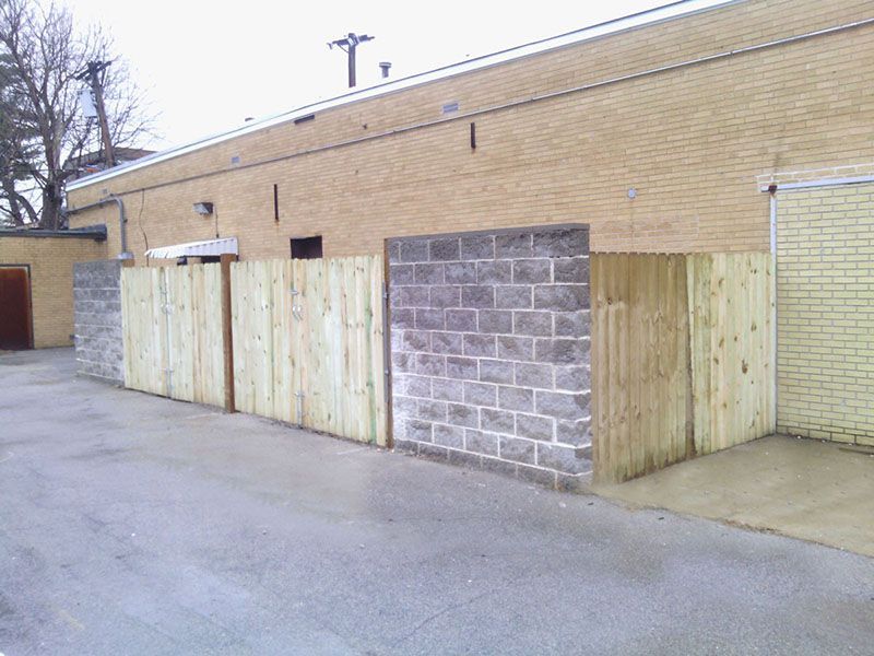 Wooden and cinder block barriers in front of a beige brick building