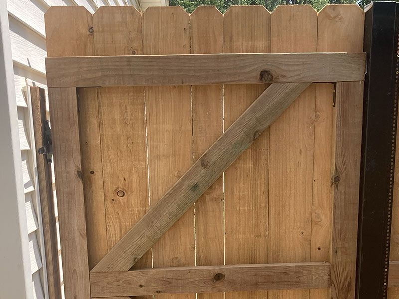 Wooden fence gate with diagonal brace and metal latch, viewed close up