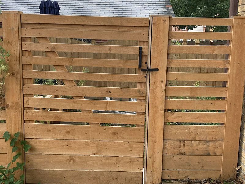 Wooden backyard fence with a latched gate and horizontal slats