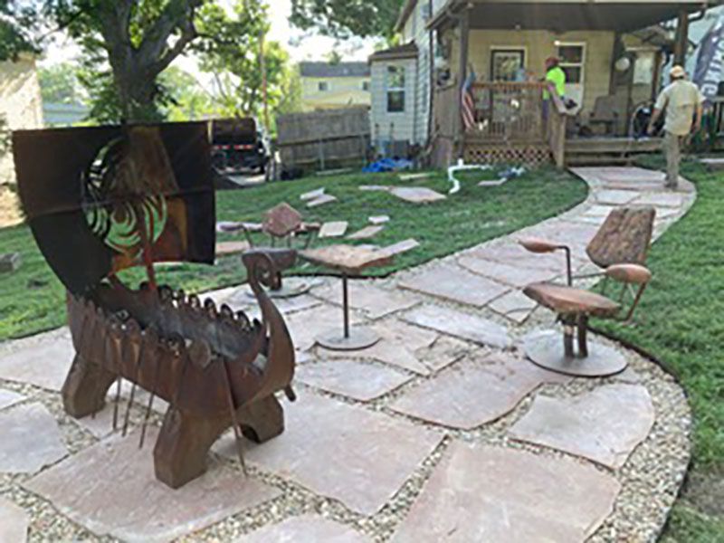 Backyard patio with stone path, lawn, and a rust-colored metal horse sculpture