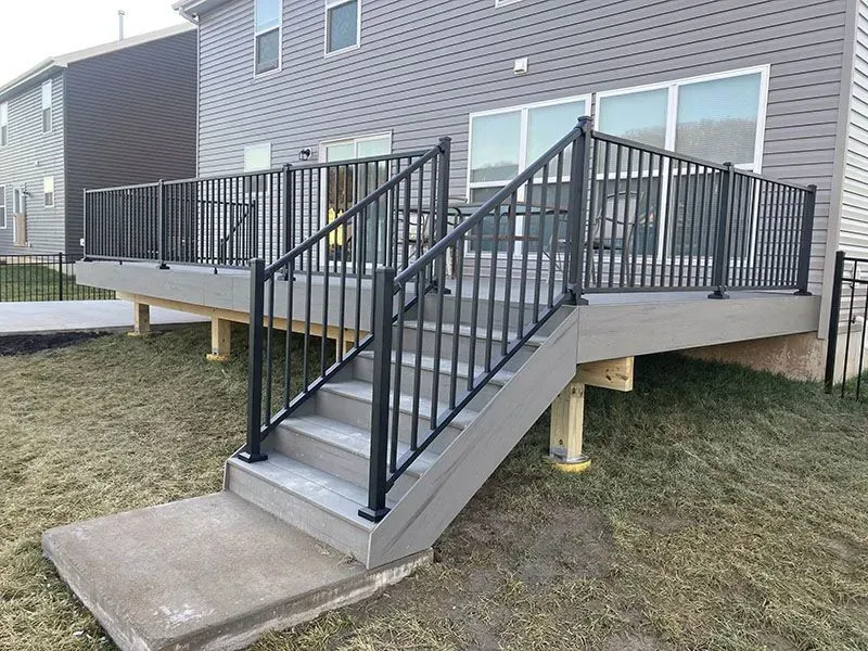 Concrete exterior stairs and black metal accessibility ramp leading to a building entrance