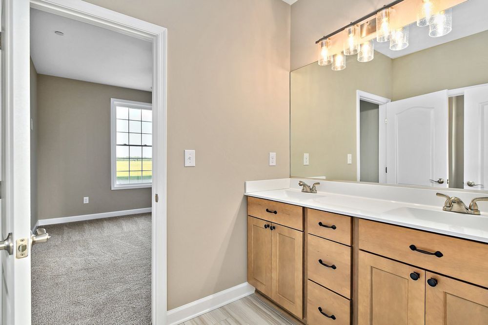 A bathroom with two sinks, and a large mirror.