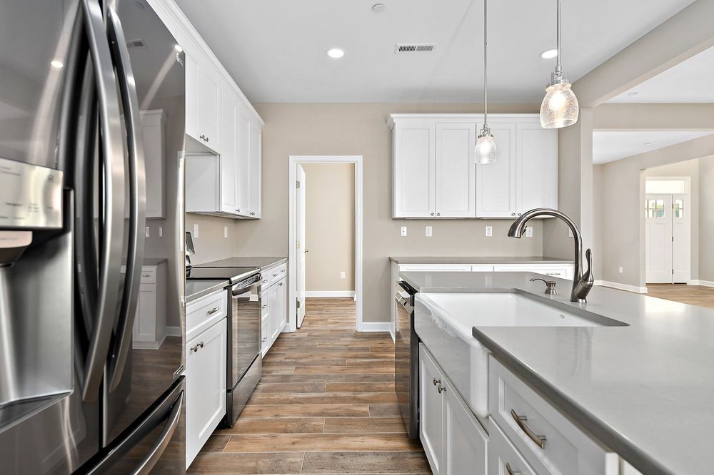 A kitchen with stainless steel appliances and white cabinets