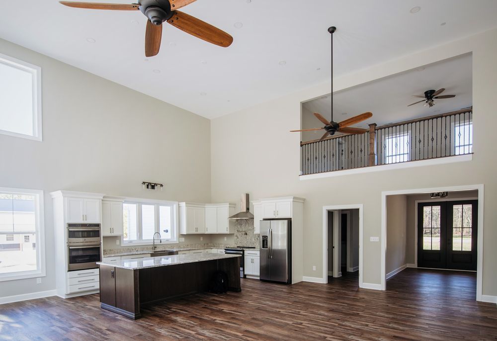 A kitchen with a large island and a ceiling fan.