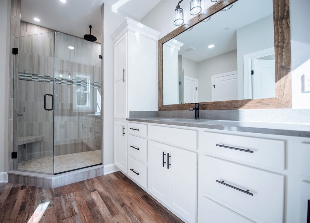 A bathroom with a walk in shower and a large mirror.