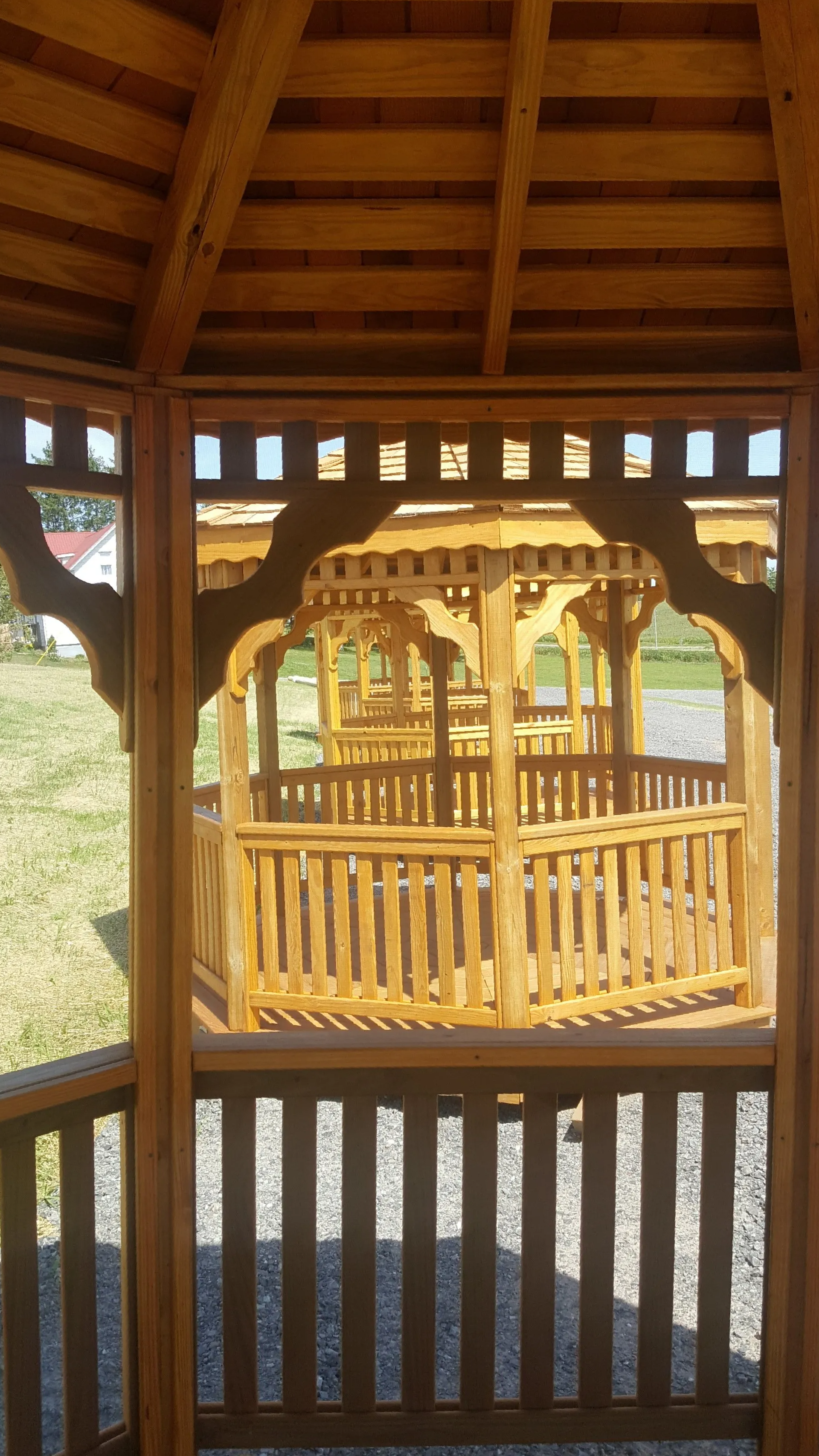 The inside of a wooden gazebo with a fence around it.