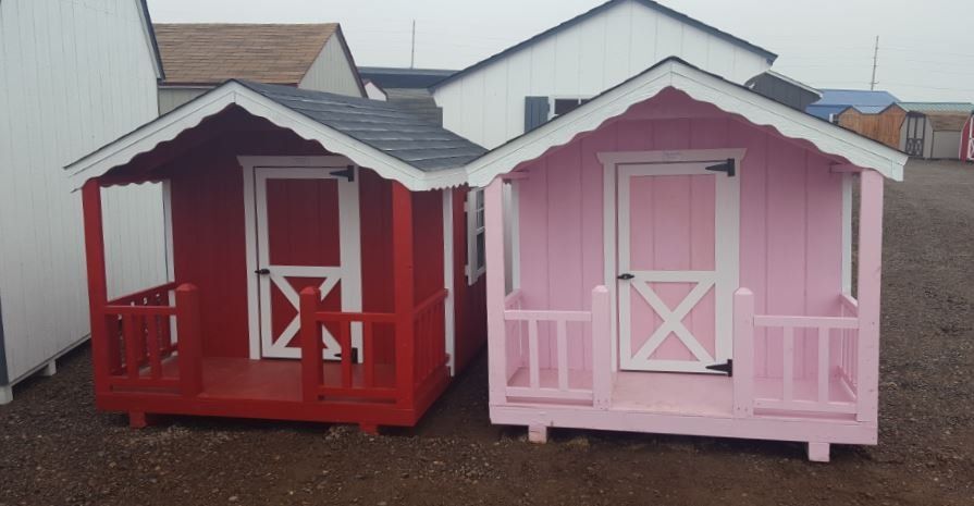 A red and a pink playhouse are sitting next to each other