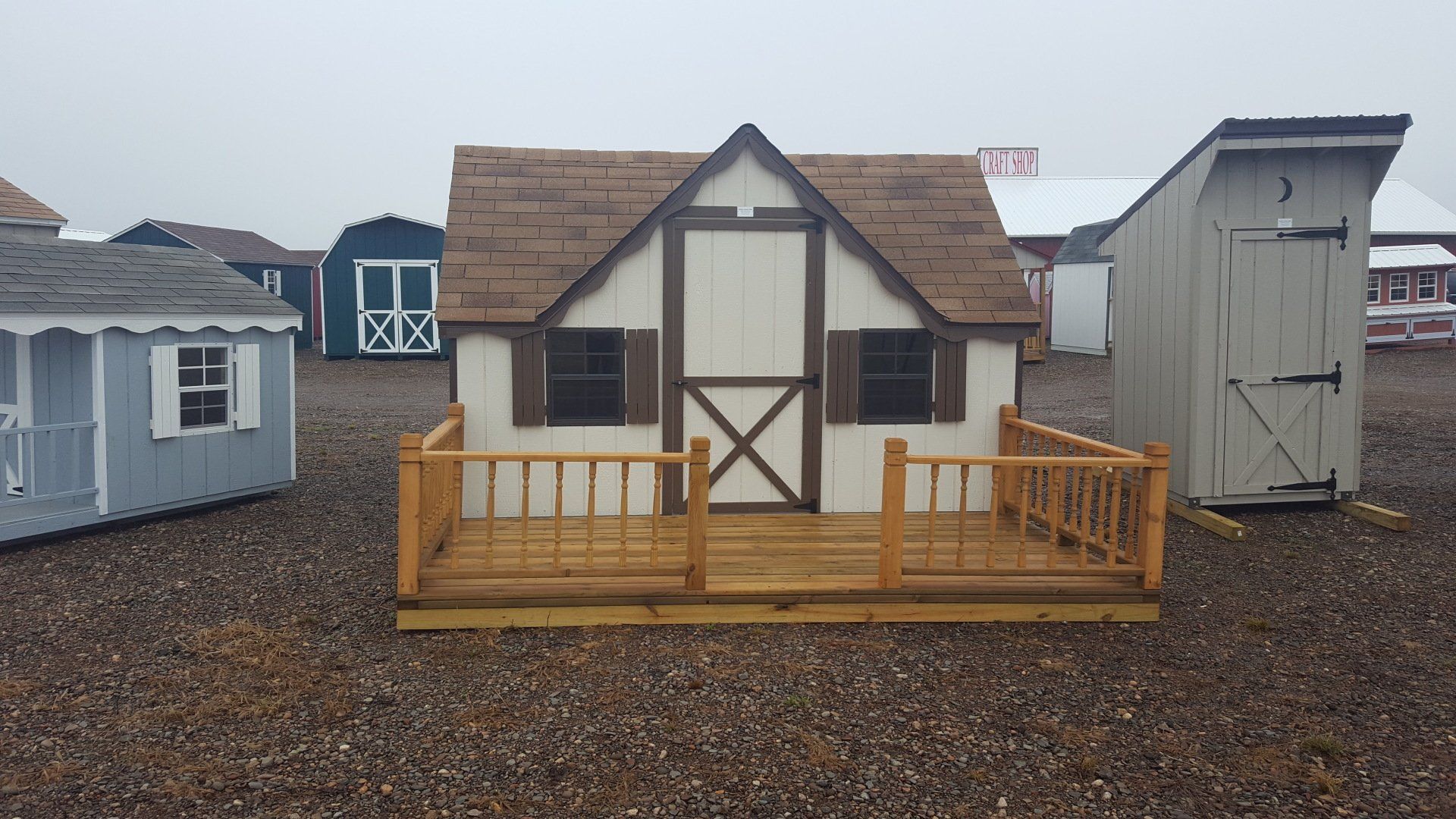 A small house with a porch is sitting on top of a pile of gravel.