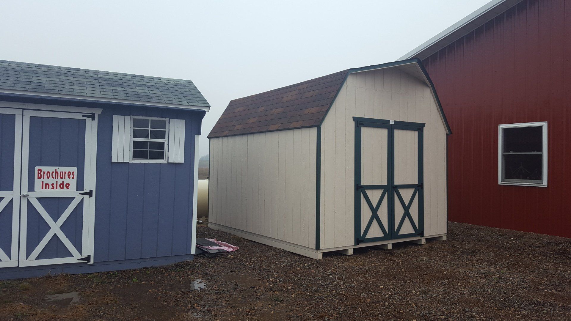 A blue shed has a sign on the door that says barrels inside