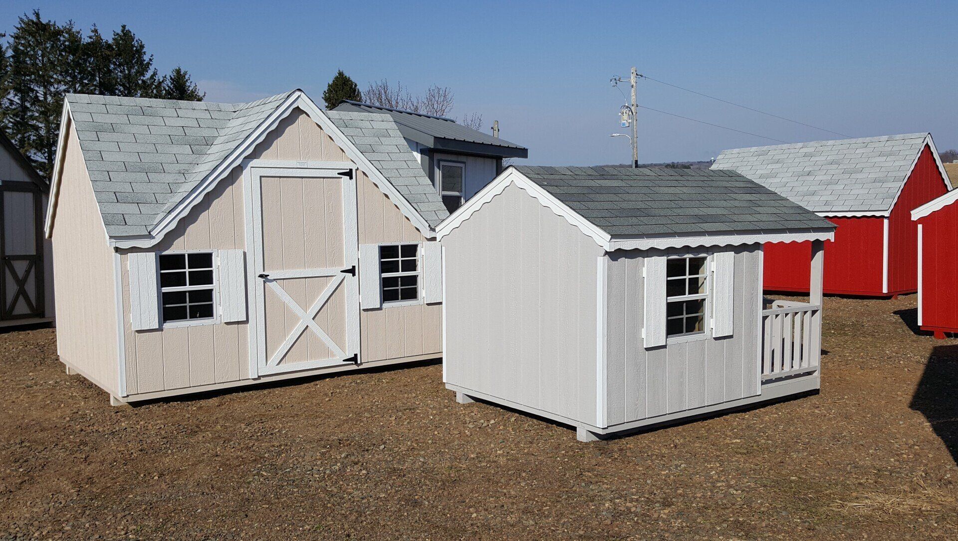 A group of sheds are sitting on top of a dirt field.