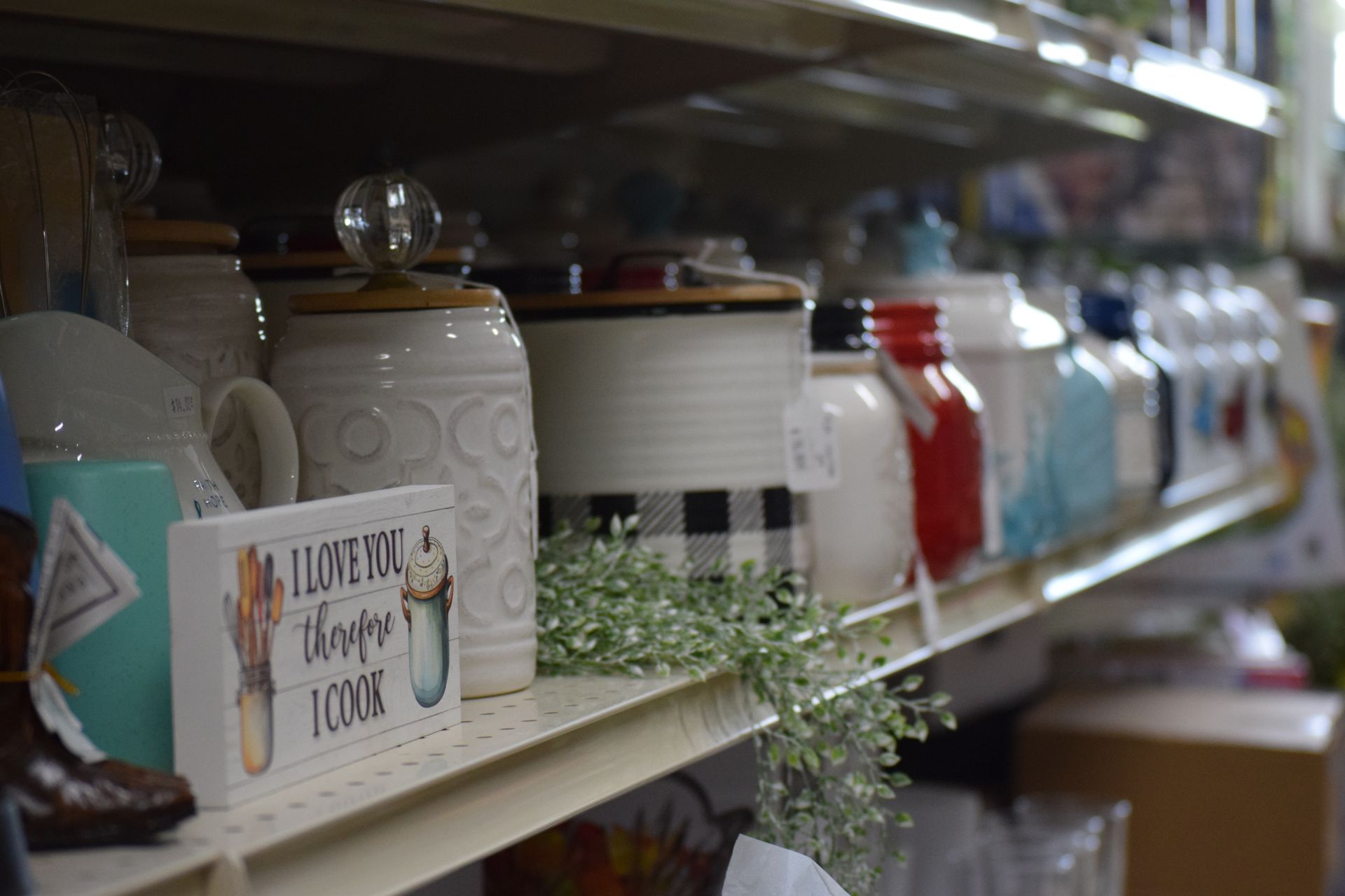 A shelf filled with jars and mugs in a store.