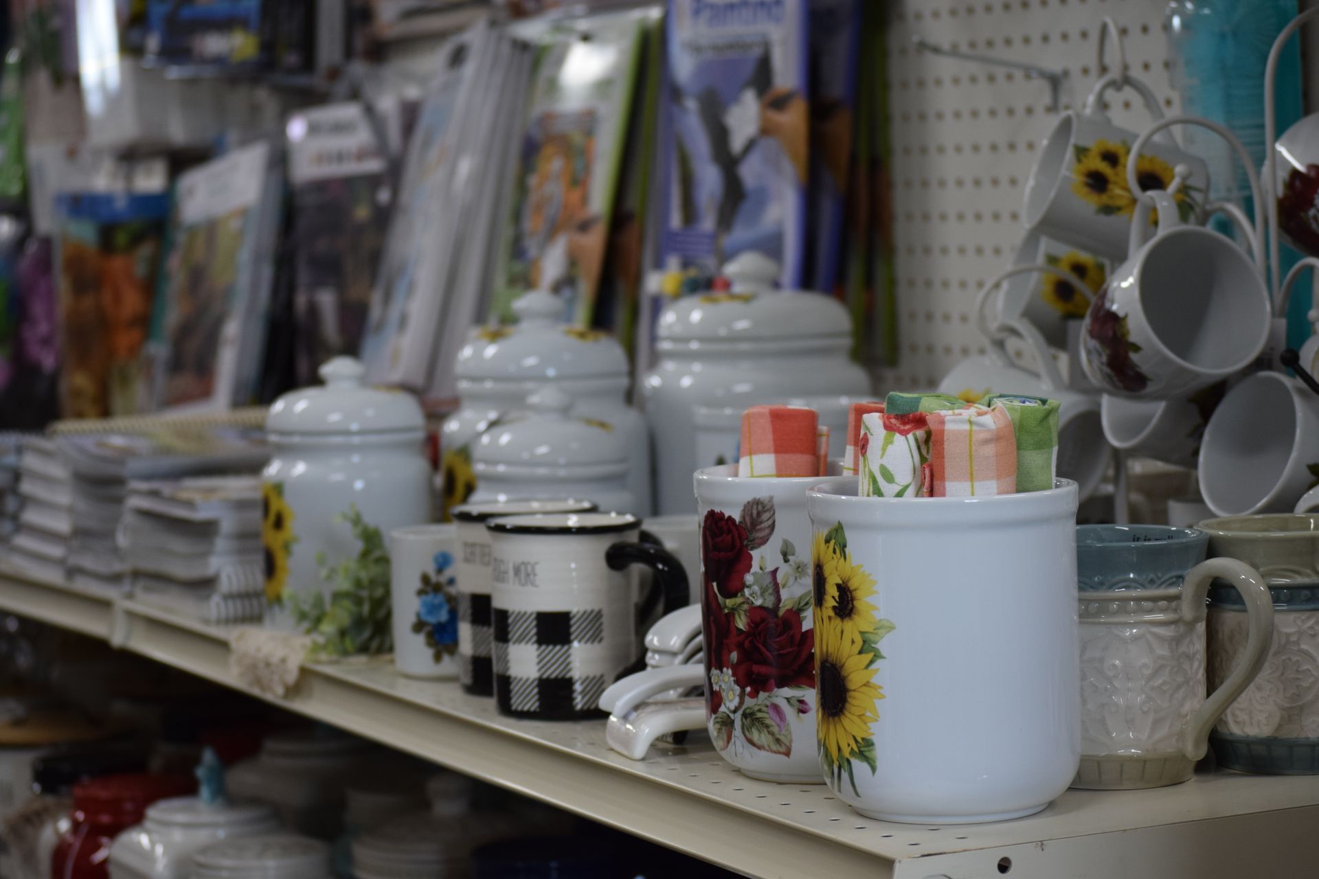 A shelf filled with jars and mugs in a store.