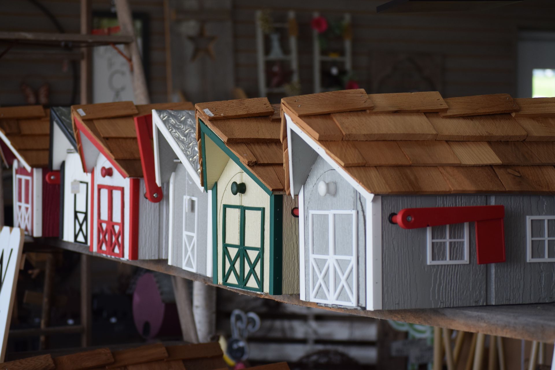 A row of wooden houses are lined up on a shelf.