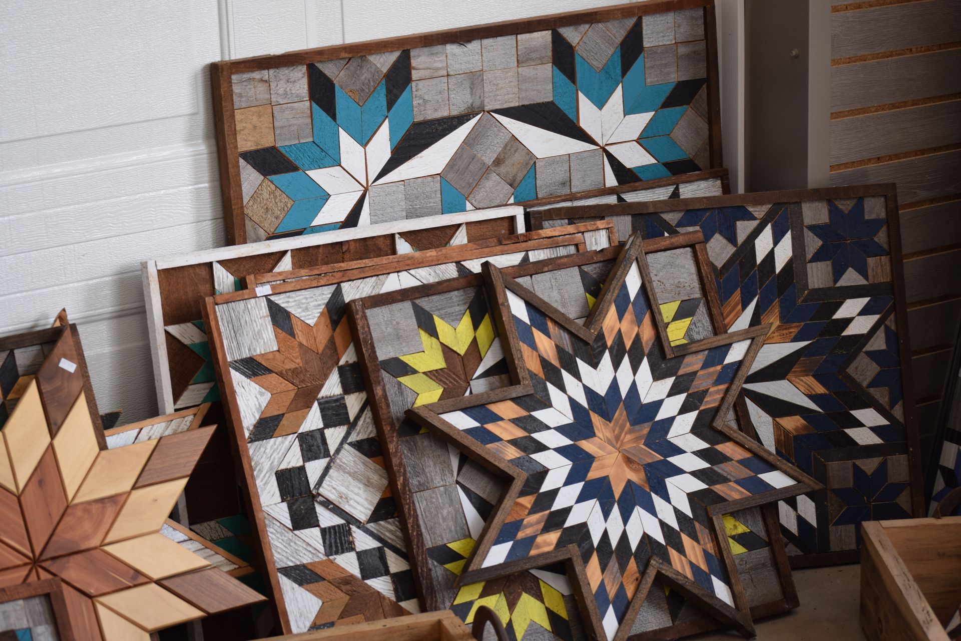 A bunch of wooden quilts are stacked on top of each other on a table.